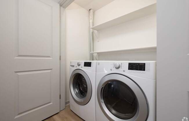 A white washing machine sits in a laundry room.