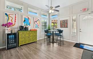 a room with a table and chairs and a ceiling fan