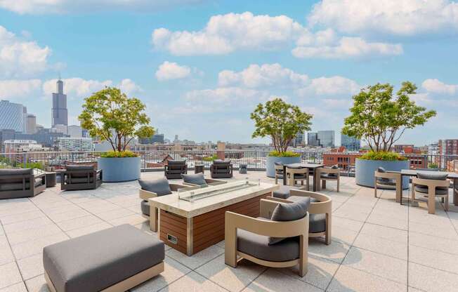 A rooftop patio with a table and chairs overlooking a city skyline.