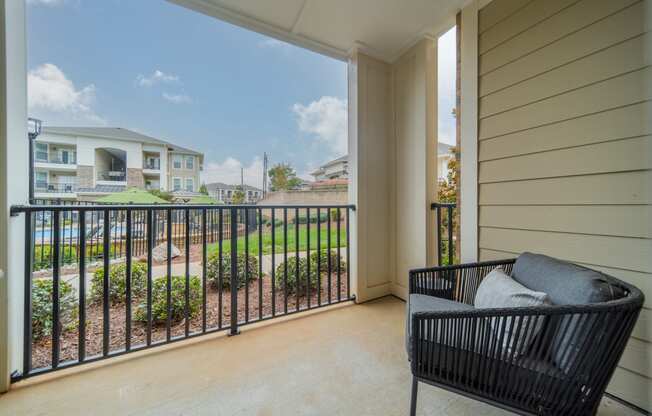 a balcony with a chair and a view of a yard and some houses