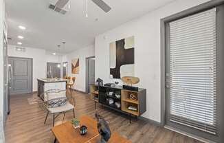 A modern living room with a wooden floor and a ceiling fan.