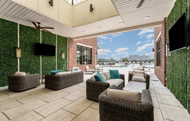 a covered patio with wicker furniture and a flat screen tv