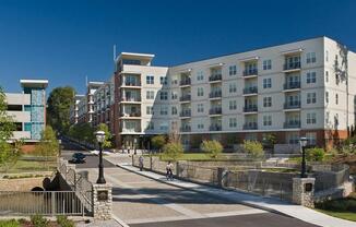 an apartment building on a city street with a bridge