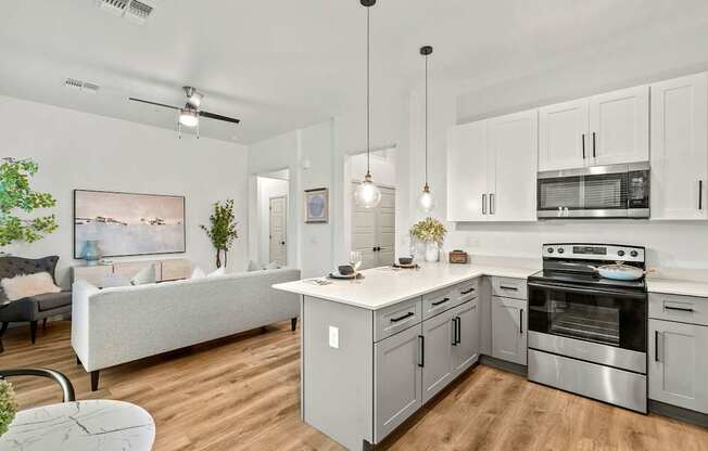 A modern kitchen with a white island and stainless steel appliances.