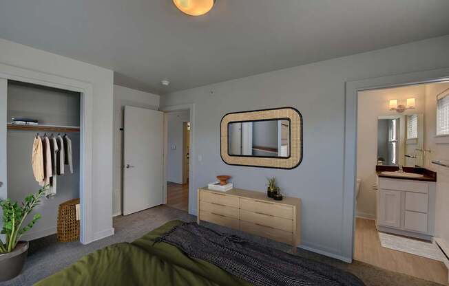 A bedroom with a bed, dresser, mirror, and closet.