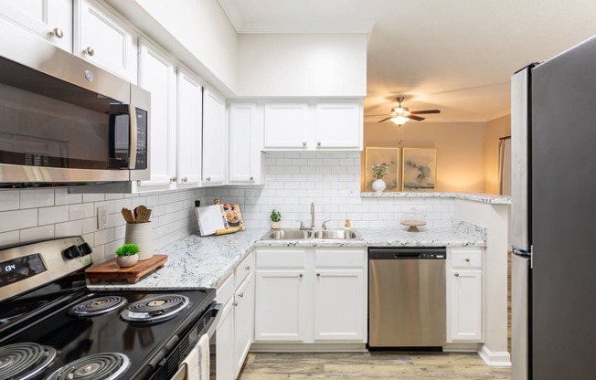a kitchen with white cabinets and stainless steel appliances