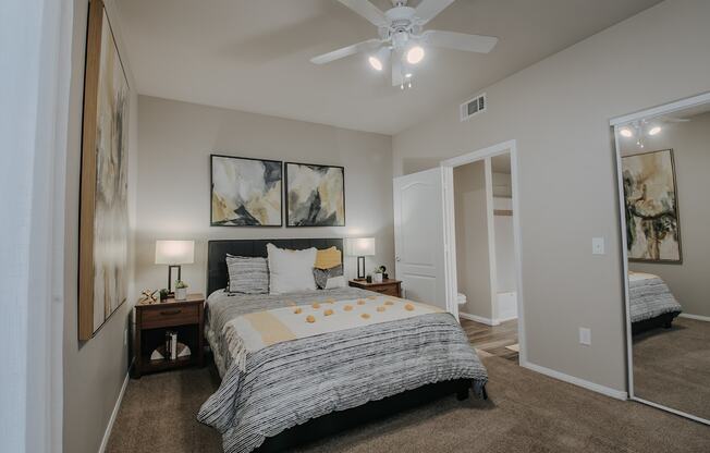 A bedroom with a large bed and a ceiling fan.