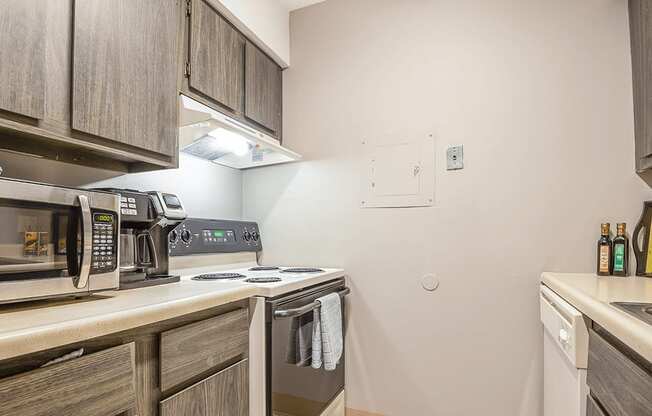 a kitchen with a stove and microwave and wooden cabinets