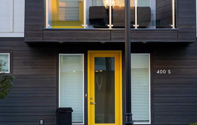 A building with a yellow door and a black lamp post in front.