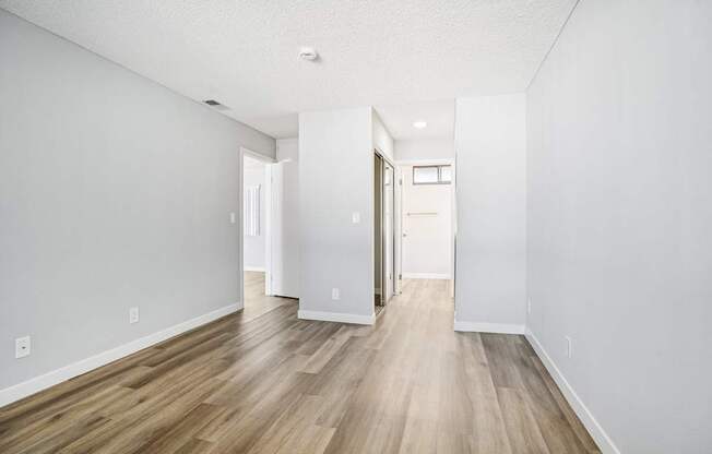 A long hallway with wood floors and white walls.
