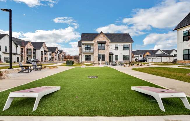 a green lawn with benches in front of houses at The BLVD at Wilson Crossings, Wyoming, 49418