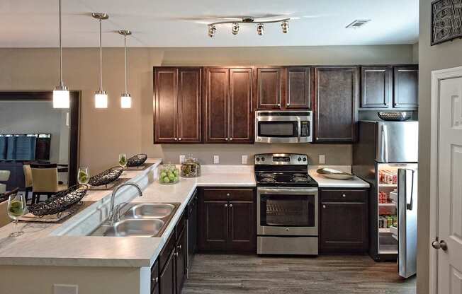 A kitchen with dark brown cabinets and stainless steel appliances.