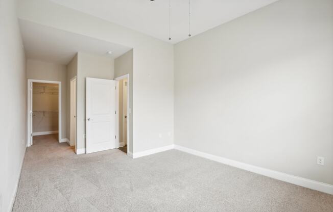 an empty room with white walls and a ceiling fan