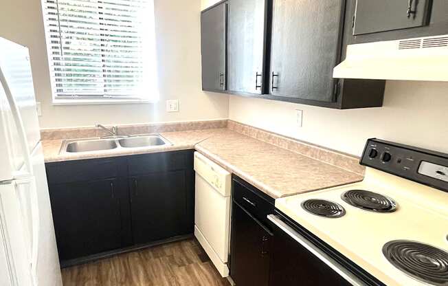 a kitchen with black cabinets and white appliances and a stove