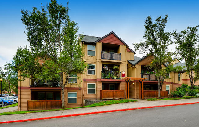 Happy Valley OR Apartments - Sunnyside Village - Entrance to Community with Trees, Sidewalk, and Sign