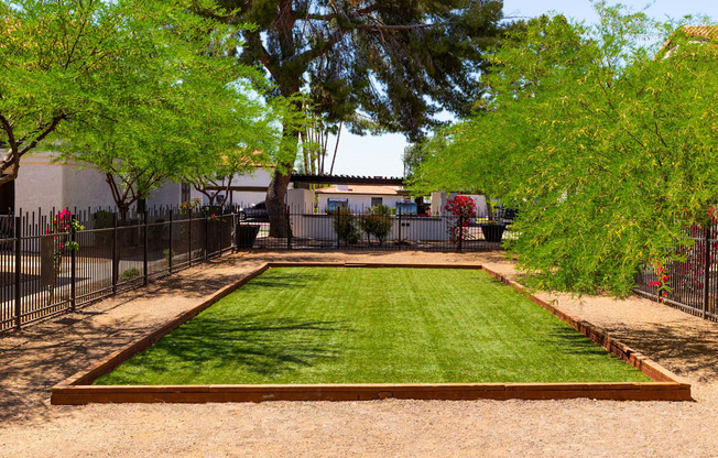 a backyard with a grassy area and a black fence