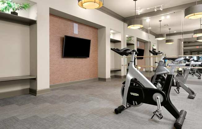a gym with exercise machines and a tv in the corner