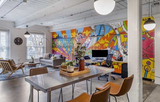 a living room with a table and chairs and a mural on the wall at Highland Mill Lofts, Charlotte, North Carolina
