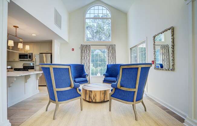 a living room with two blue chairs and a coffee table