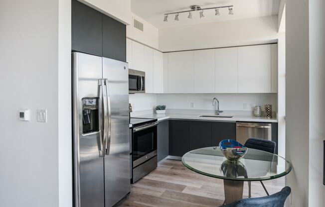 Miami Apartments for Rent - MB Station - Kitchen with a Grey and White Color Scheme, Hardwood Flooring, and Stainless Steel Appliances