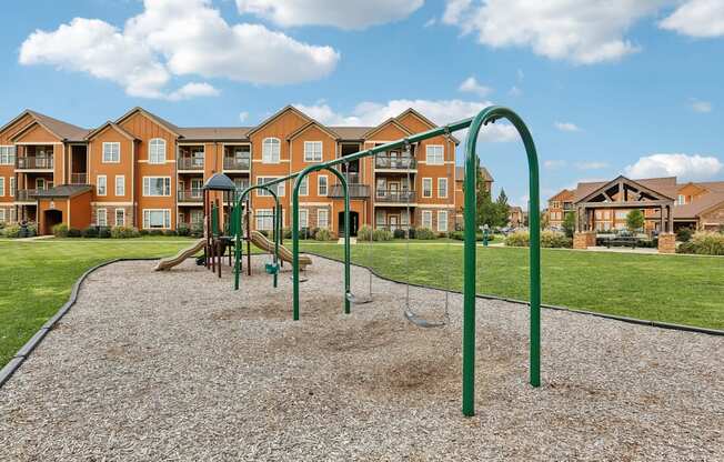 an empty playground with an apartment building in the background