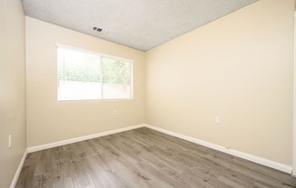 a bedroom with hardwood floors and beige walls at Sagewood Gardens Senior Apartments, Hacienda Heights, 91745