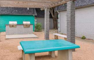 a blue picnic table and benches in a courtyard