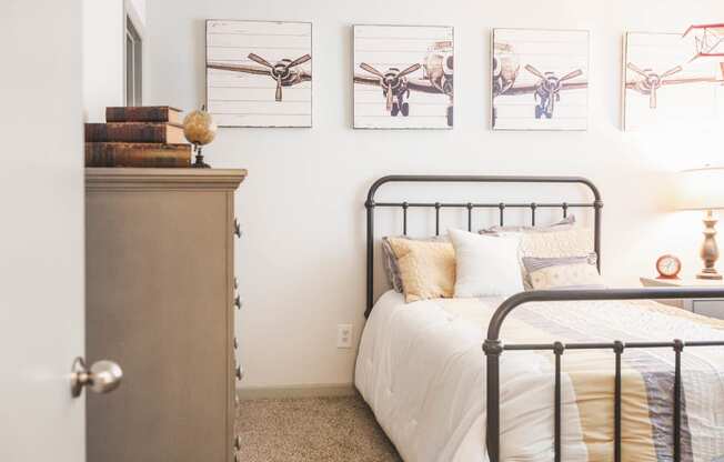a bedroom with a bed and pictures of airplanes on the wall