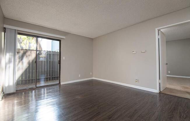 A room with wooden floors and a sliding glass door.