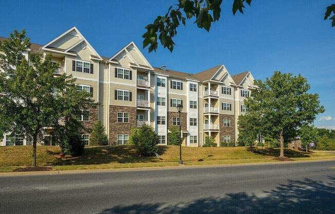 an exterior view of an apartment building on the side of a street