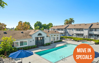 A pool surrounded by chairs and umbrellas with a sign that says "Move in Specials".