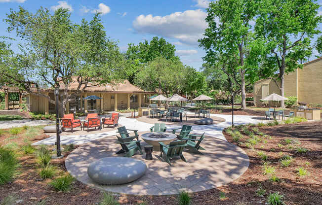 an outdoor patio with tables and chairs and trees at Summerwood Apartments, Santa Clara, 95050