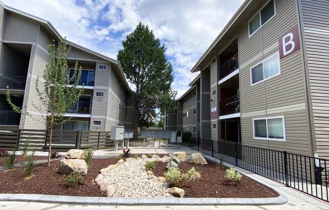 an outdoor area with rocks and plants in front of an apartment building  at Talavera, Boise, Idaho