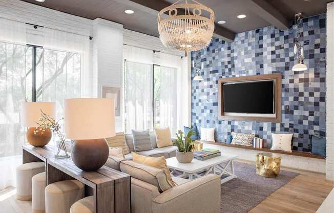 A modern living room with a large sofa, a wooden coffee table, and a chandelier.