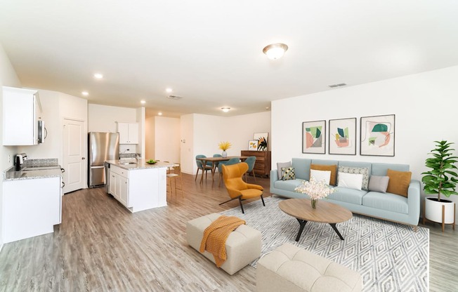 a living room with contemporary furnitures, decors, white walls and hardwood flooring