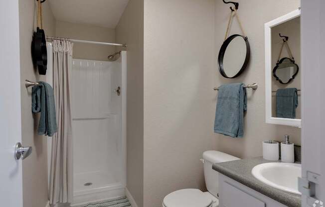 A bathroom with a toilet, sink, and shower.