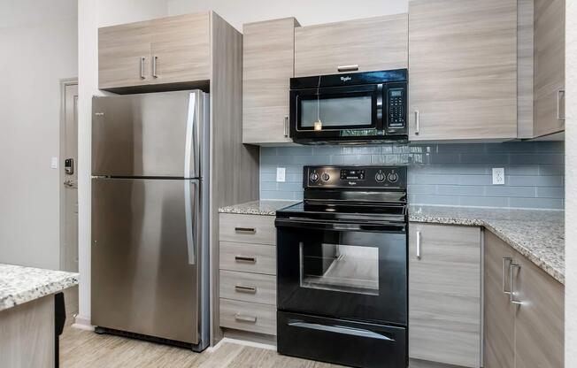 a modern kitchen with stainless steel appliances and wooden cabinets