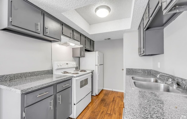 A kitchen with white appliances and a granite counter top.