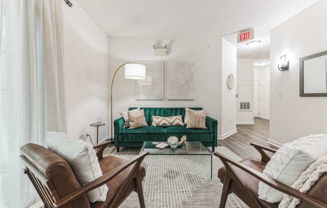 the living room of an apartment with a green couch