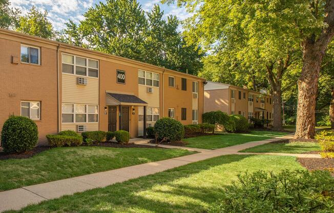 a large brick building with grass in front of a house