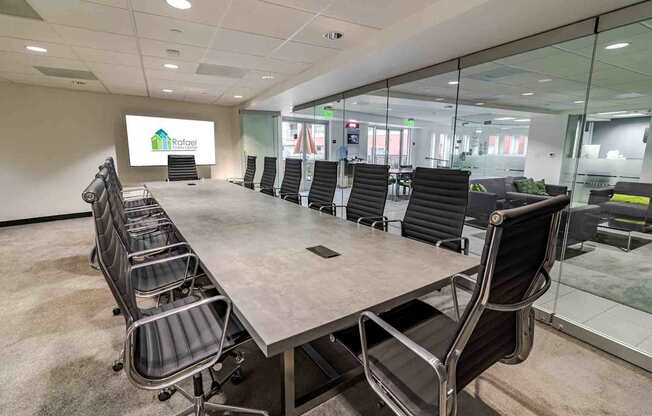 A conference room with a long table and chairs, and a sign that reads "Rafael".