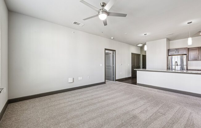 A room with a ceiling fan and carpeted floor.