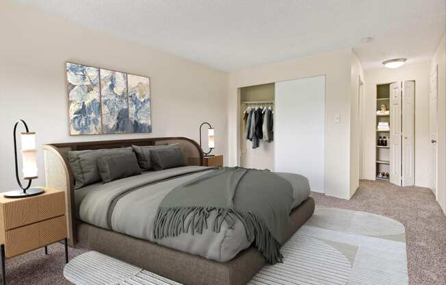 A renovated bedroom with a large bed, closet  and beautiful wall art at  Foster Creek apartments in Tukwila, WA