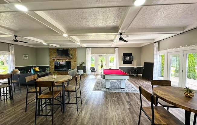 Interior of the clubhouse at Woodbridge Apartments in Bloomington, featuring furniture, pool table, and seating areas.
