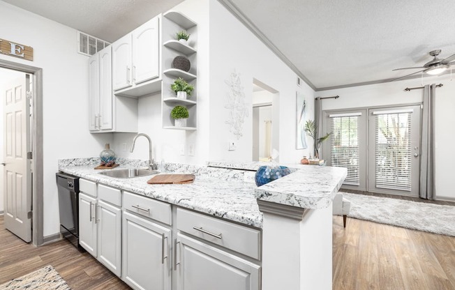 A kitchen with white cabinets and countertop at The Palms at Chatham apartments in Savannah GA.