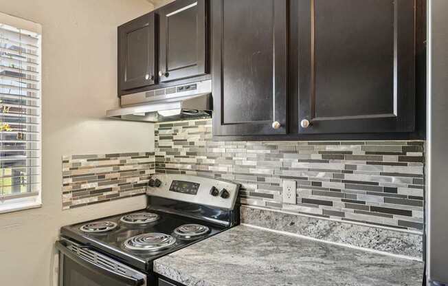 A kitchen with a stove and cabinets.