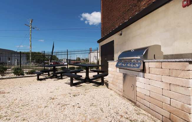 a barbecue grill and picnic table outside of a building at Mayton Transfer Lofts, Petersburg, 23803