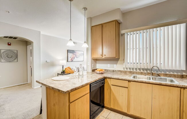 a kitchen with wooden cabinets and a counter top with a sink at Adiamo Palm Valley, Goodyear, 85395