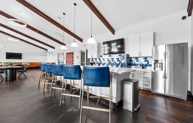 A kitchen with blue chairs and a white counter.
