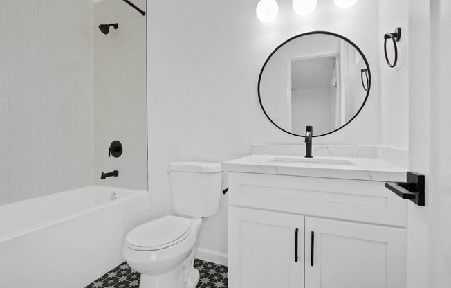 a white bathroom with a white toilet and a sink